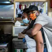 A man hugs a woman from behind in the Welton Street Cafe