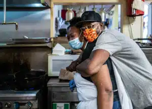 A man hugs a woman from behind in the Welton Street Cafe