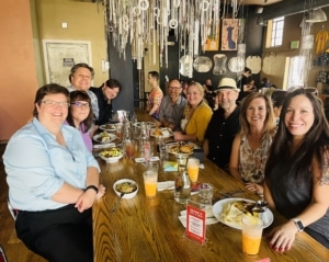 Staff members of the DCPA sit at a table and smile for a photo