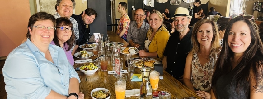 Staff members of the DCPA sit at a table and smile for a photo