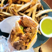 A close up of a gyro with fries