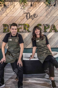 Two people sit in on a tub in the Beer Spa