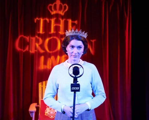 A woman stands in front of an old fashioned microphone