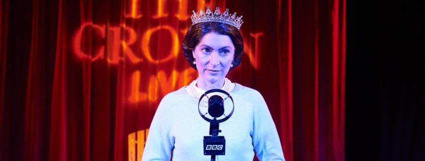 A woman stands in front of an old fashioned microphone