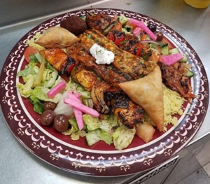 A full plate of Mediterranean food on a decorative plate