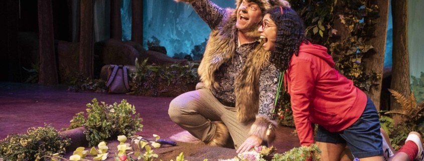 The wolf and Little Red kneel by a garden as the wolf holds up a vegetable