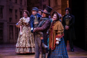 The cast of A Christmas Carol stands together onstage