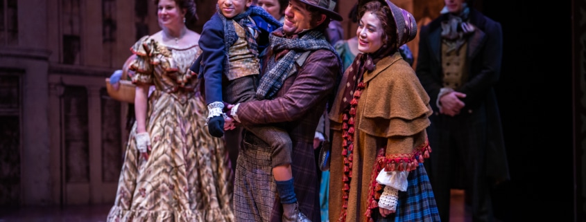 The cast of A Christmas Carol stands together onstage