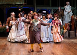 group of actors in period costumes performing on stage.