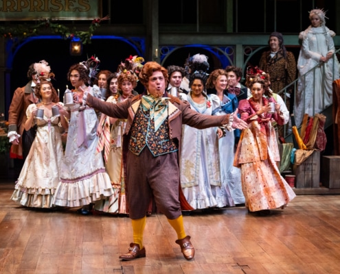 group of actors in period costumes performing on stage.