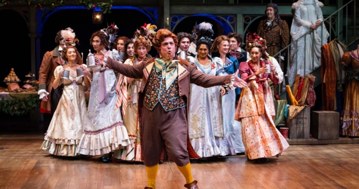 group of actors in period costumes performing on stage.