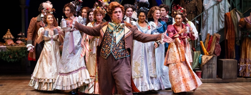 group of actors in period costumes performing on stage.