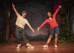 Shepard Boy and Little Red pose with their arms stretched