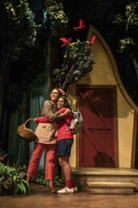 Mother hugs Little Red in front of their house