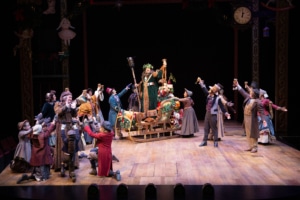 The cast of A Christmas Carol gathers around the ghost of Christmas present