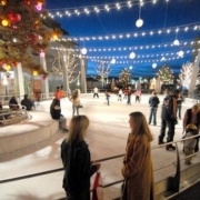 People mill around and skate at an outdoor ice rink