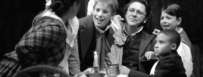 The Cratchit family crowds around a table in A Christmas Carol