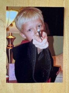 A young Erik Peterson holds a wand toward the camera