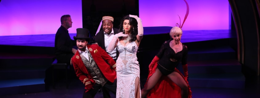 A group of actors dance dressed like Moulin Rouge characters