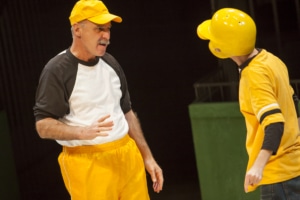 A baseball coach gives instruction to a young player wearing a helmet in Jackie & Me