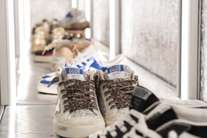 Sparkling tennis shoes lined up on a shelf in Golden Goose