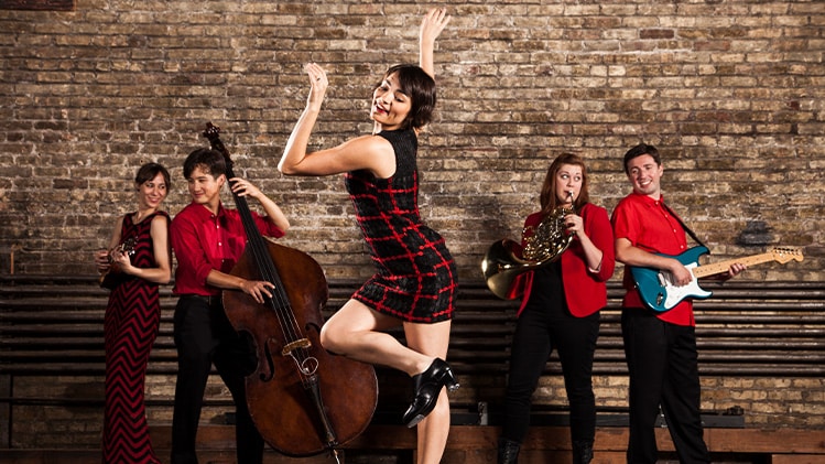 A tap dancer performs in front of live musicians