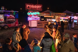 People gather around a fire pit at Camp Christmas