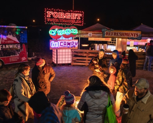 People gather around a fire pit at Camp Christmas