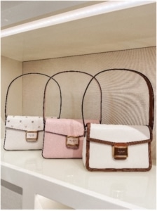 Purses lined up on a shelf in Kate Spade