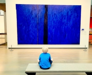 A child sits in front of a painting at the Clyfford Still Museum