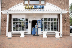 A woman poses at the door to Deja Blue Boutique