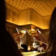 A couple clinks together their cocktail glasses at range restaurant