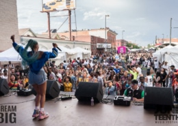A woman performs in front of a large crowd at Juneteenth Music Festival