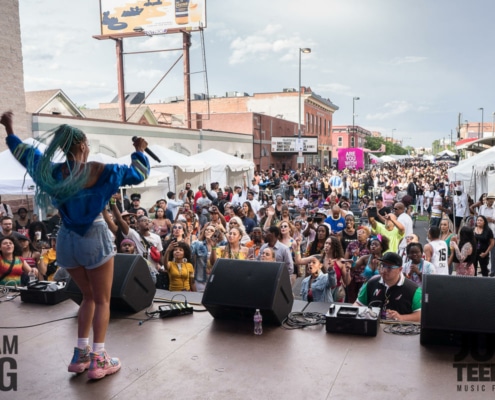 A woman performs in front of a large crowd at Juneteenth Music Festival