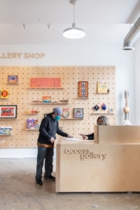 A person purchases artwork inside Access Gallery