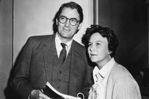 Gregory Peck and Harper Lee stand together holding a script