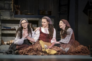 Chava, Tzeitel, and Hodel sit on the floor together in Fiddler on the Roof