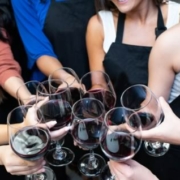 Women toast with wine glasses at a painting class