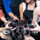 Women toast with wine glasses at a painting class