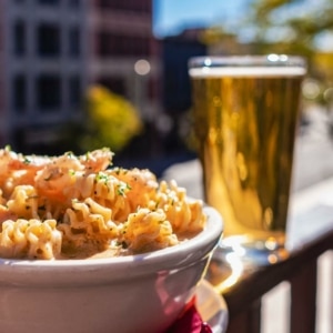 A plate next to a full cup of beer at Nola Jane