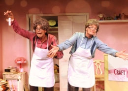 Linda Klein and Barbara Gehring dressed as older women show off their homemade crafts