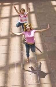 Linda Klein and Barbara Gehring play hopscotch down a sidewalk