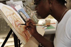 Artist Adri Norris paints a portrait in her studio, Afro Triangle