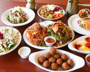 Several white plates filled with Mediterranean food at Phoenician Kebab in Denver