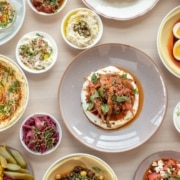 Several plates filled with Mediterranean food on a table at Safta