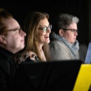 Sandy Rustin smiles as she watches The Suffragette's Murder in rehearsal