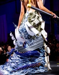 A close up of the back of a gown. A ship is nestled among waves and octopus tentacles, all made of paper.