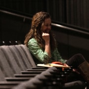 Playwright Kirsten Potter smiles while seated in the audience