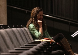 Playwright Kirsten Potter smiles while seated in the audience