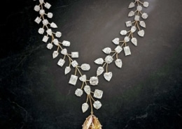 A yellow diamond pendant hangs from a diamond chain made to look like delicate leaves